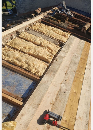 Charpente de toit en bois avec panneaux isolants et outils utilisés lors des travaux de construction