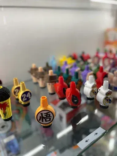 Variedad de boquillas para vaporizadores coloridos con temática de personajes en un estante de exhibición.