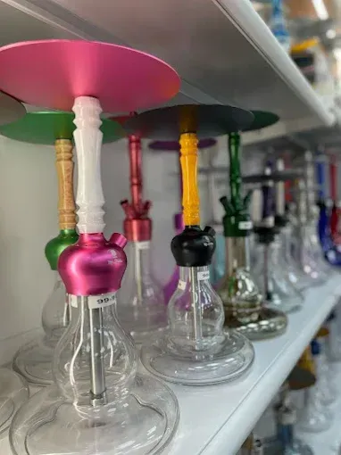 Pipas de agua de varios colores alineadas en un estante de una tienda.