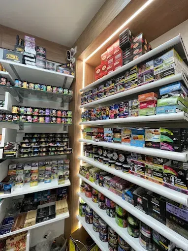 Estantes llenos de diversos productos de tabaco en una tienda bien iluminada.