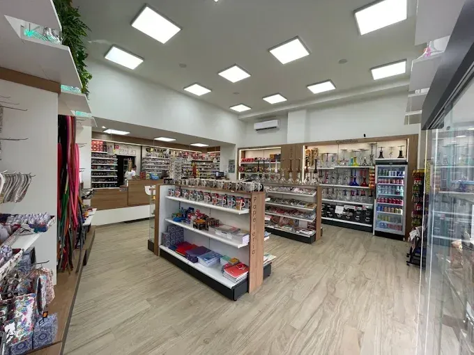 Interior de una tienda minorista bien iluminada con estantes de mercancía y piso de madera.