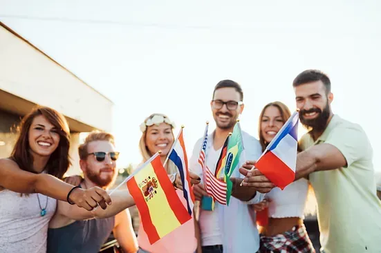 Un grupo de personas sostiene banderas de diferentes países.