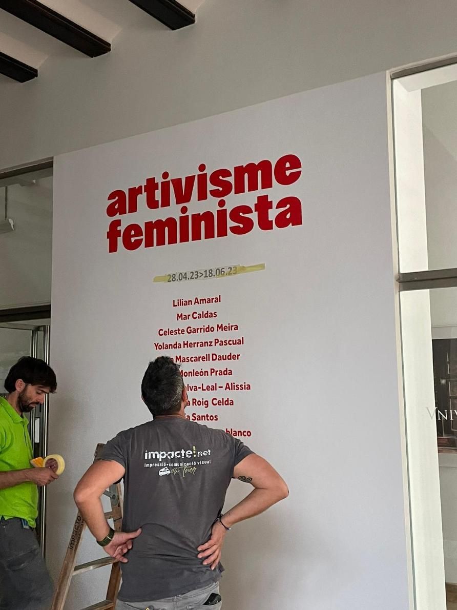 Dos personas instalando un cartel que dice 