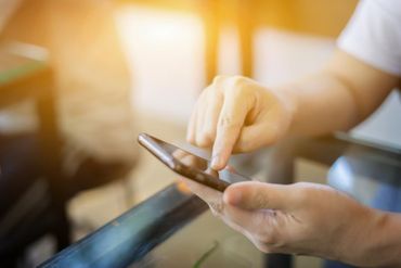 Nahaufnahme einer Person, die ein Smartphone in den Händen hält