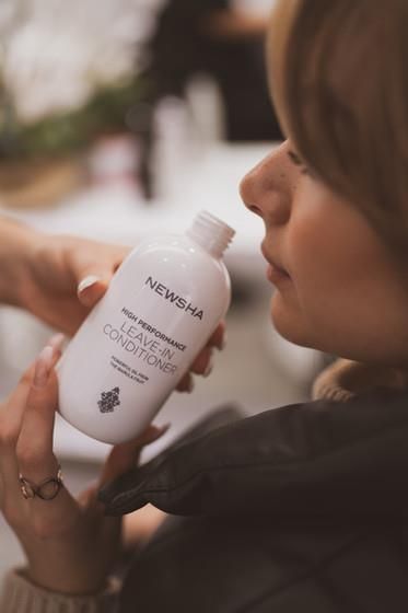 Eine Frau hält eine Flasche Spülung in der Hand.