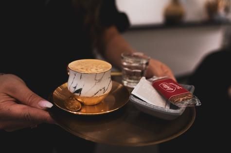 Eine Person hält eine Tasse Kaffee auf einer Untertasse.