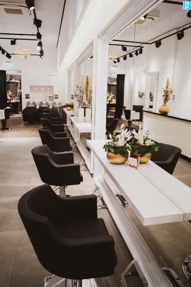 Eine Reihe schwarzer Stühle in einem Friseursalon.