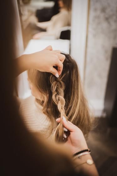 Eine Frau lässt sich in einem Salon die Haare flechten.