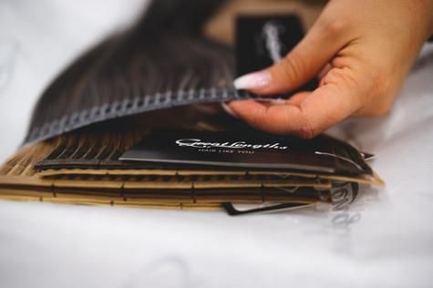 Eine Frau hält eine Haarsträhne in der Hand.