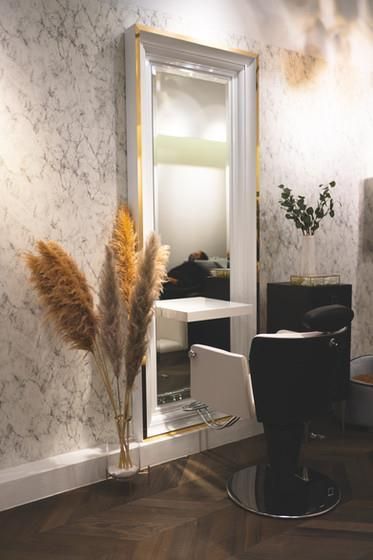 Ein Friseursalon mit großem Spiegel und Stuhl.