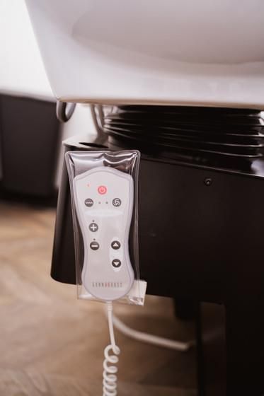 Eine Fernbedienung ist am Badewannenrand angebracht.