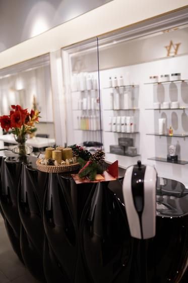 Eine lange schwarze Theke in einem Salon mit Kerzen darauf.