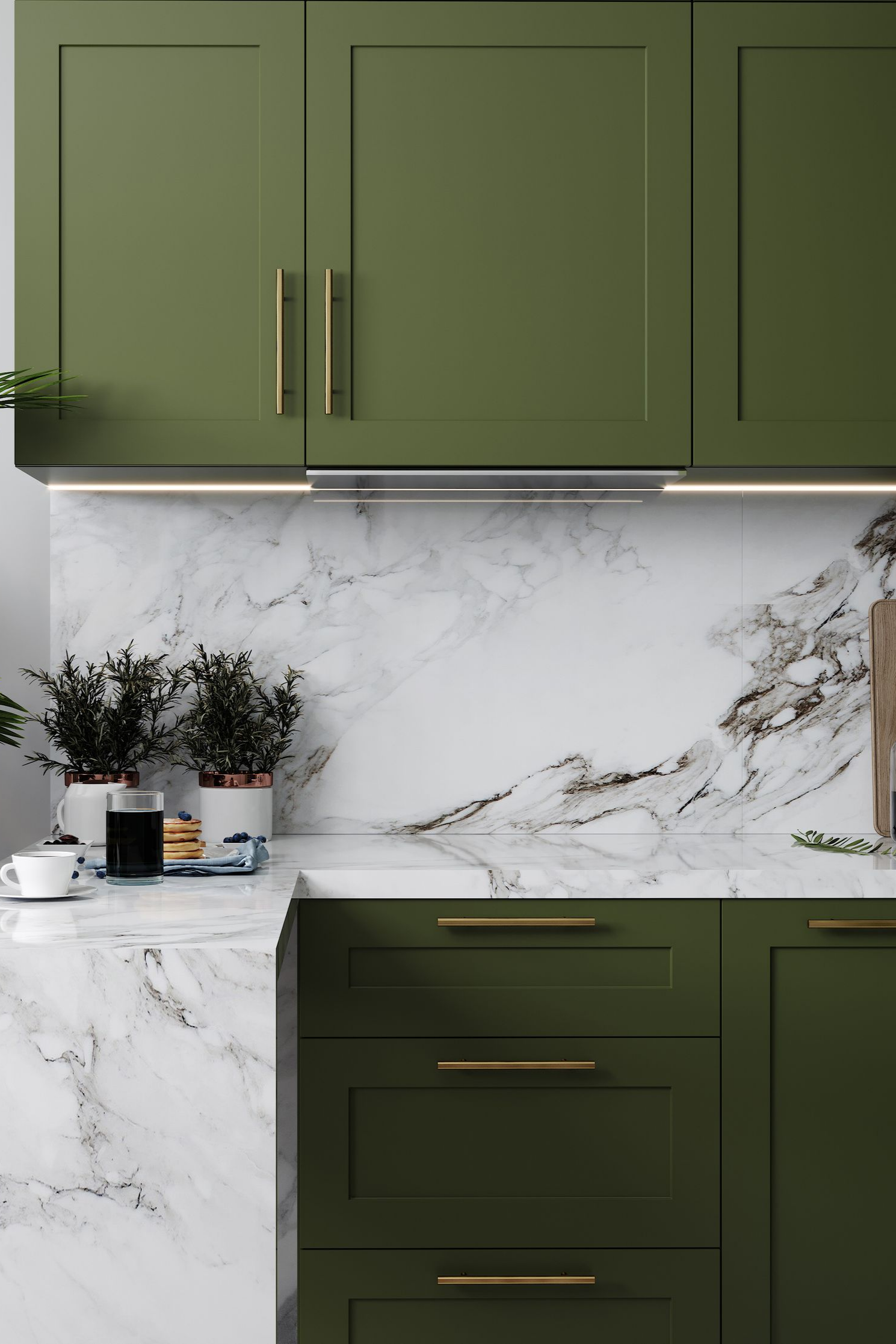 Cuisine équipée d'armoires vertes avec poignées dorées, crédence et comptoirs en marbre blanc.
