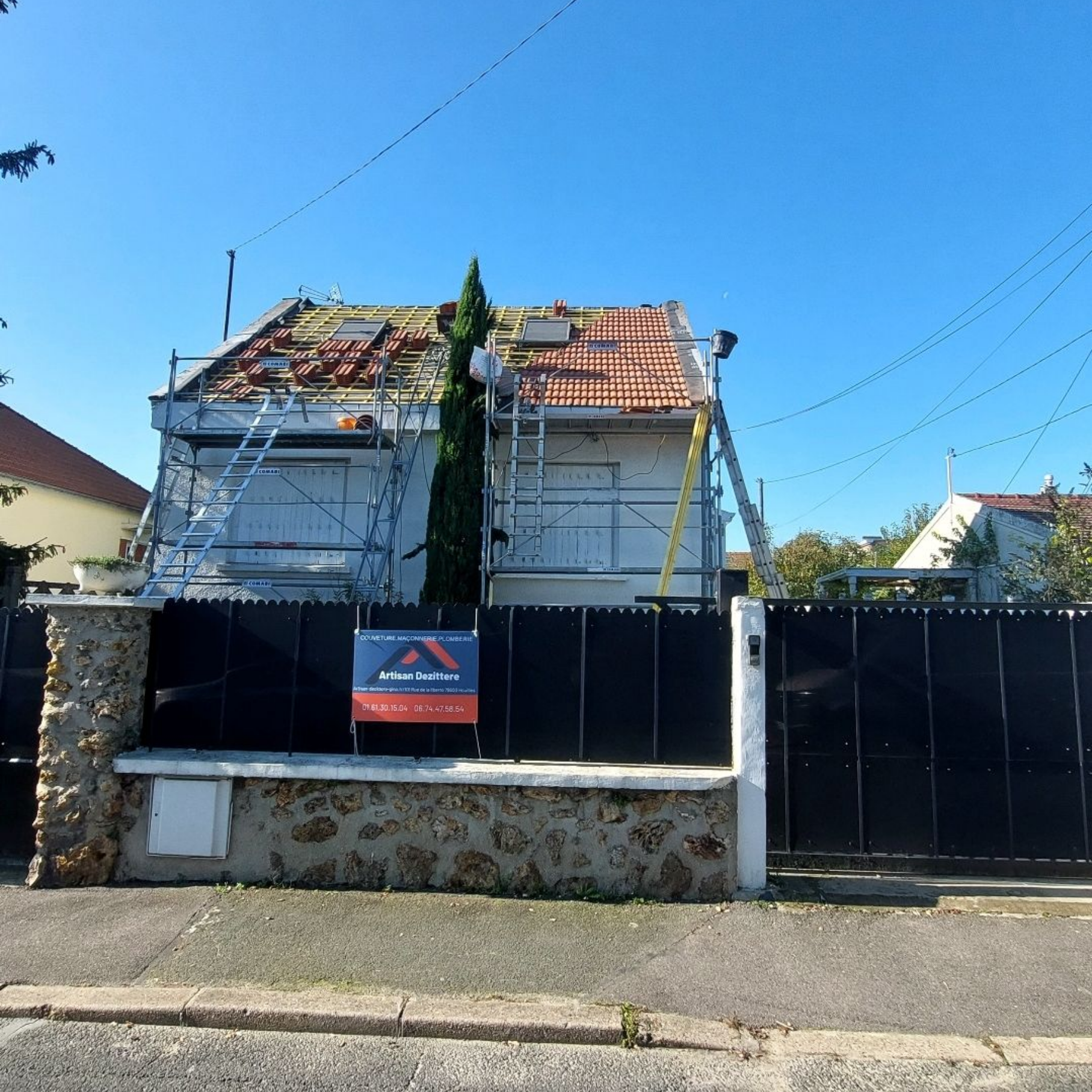 Maison avec échafaudages ; tuiles partiellement enlevées.