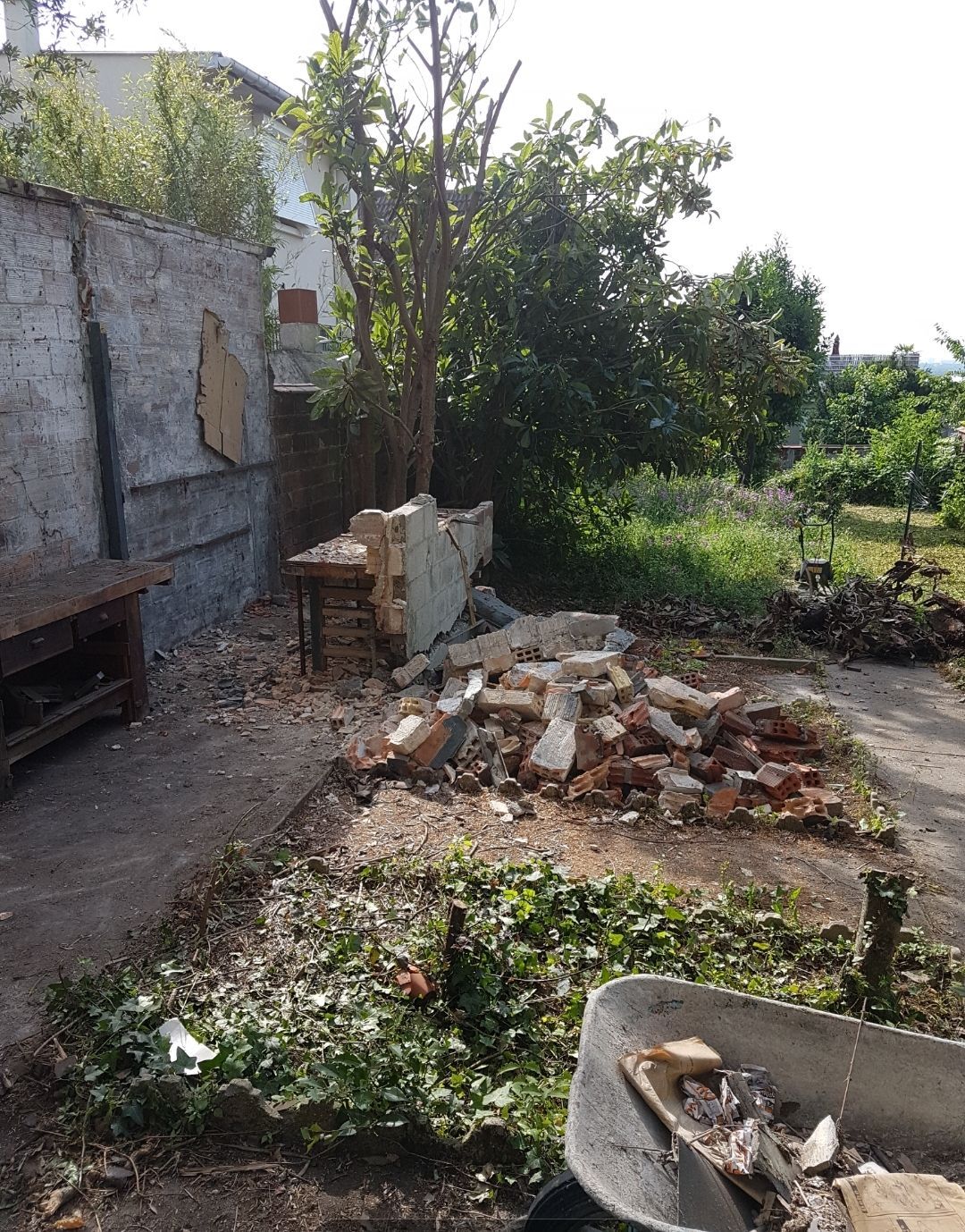 Des débris d'un mur de briques démoli jonchent le sol.