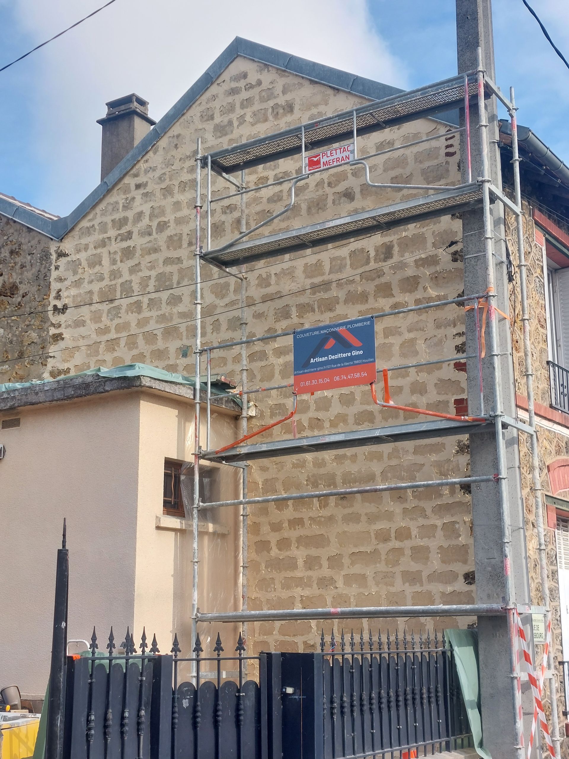 Extérieur du bâtiment avec échafaudages pour travaux de rénovation.