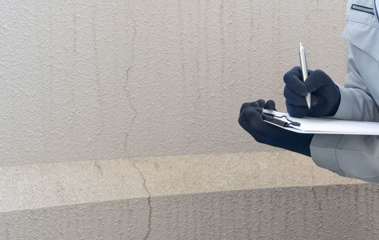 Prise de note suite à la constatation  d'une fissure sur une façade.