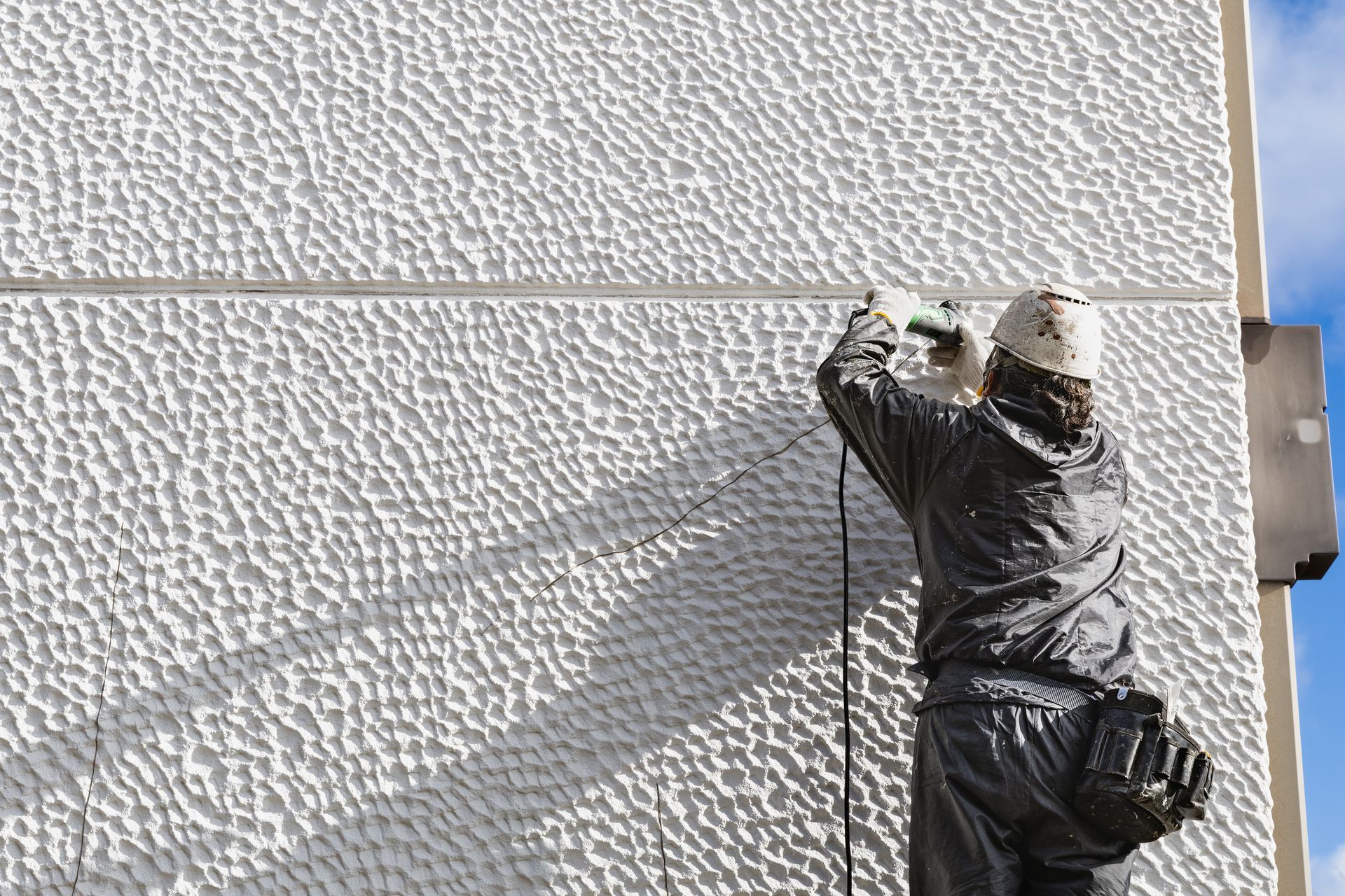 Travaux de réparation d'une fissure sur une façade.