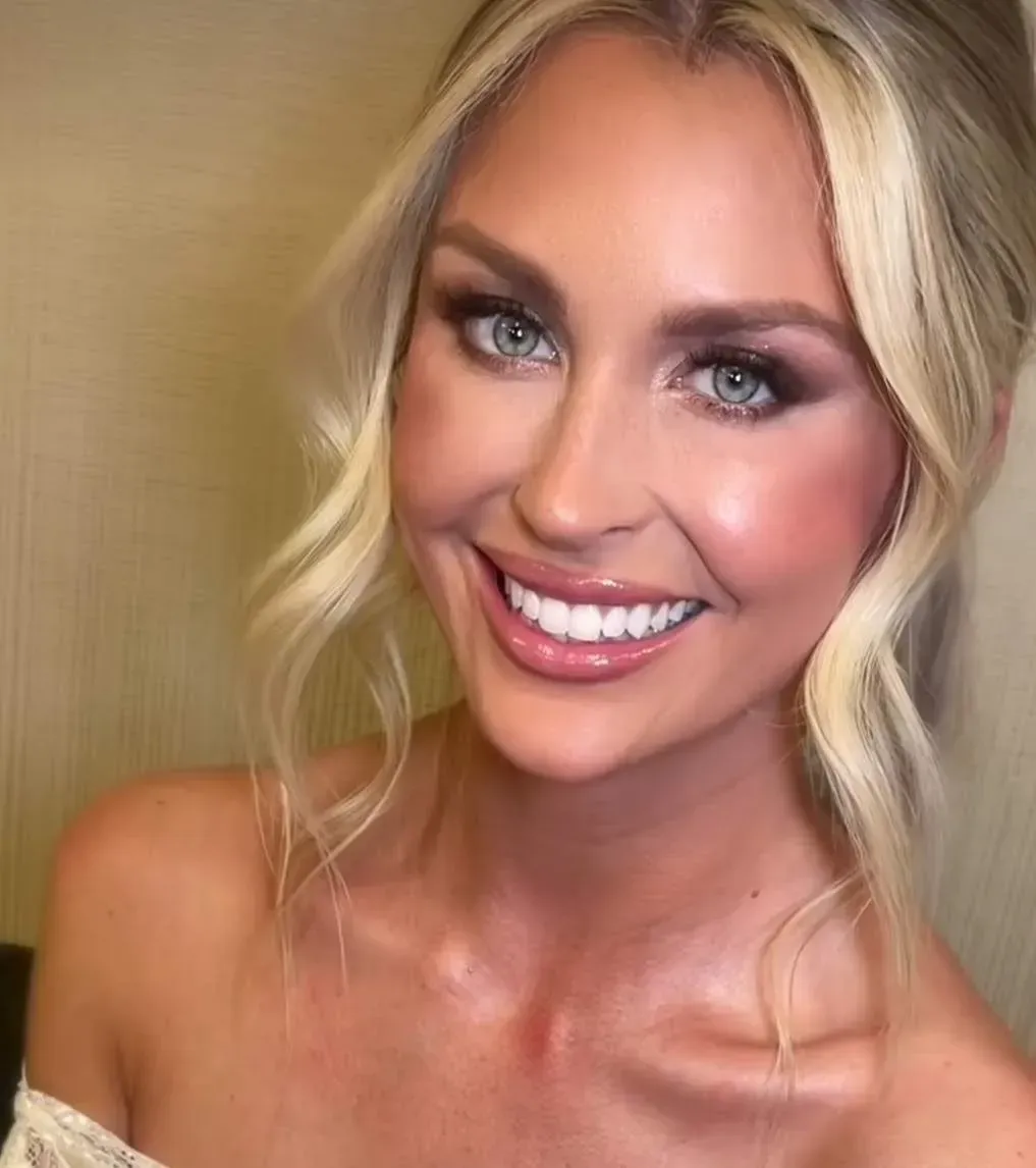 Mujer limpiando suavemente la cara con un de algodón blanco; primer plano, ojos cerrados, sonriendo.