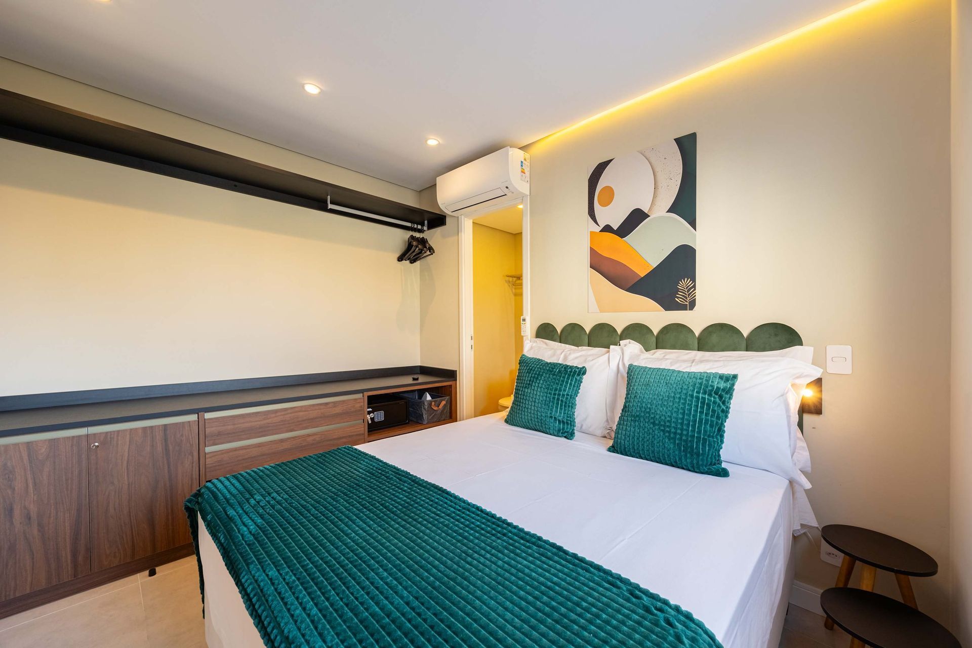 Bedroom with a bed, artwork, built-in closet, and teal accents.