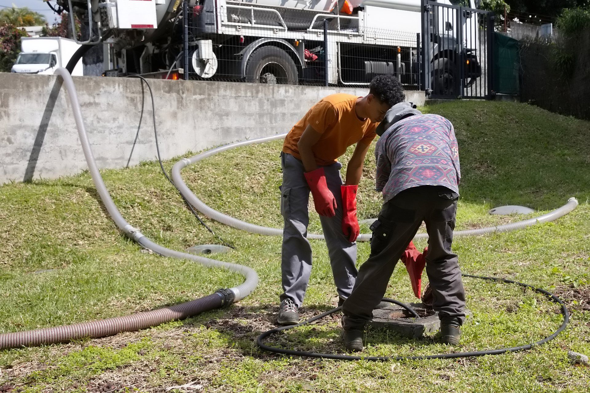 Deux vidangeurs en train de travailler sur une fosse septique