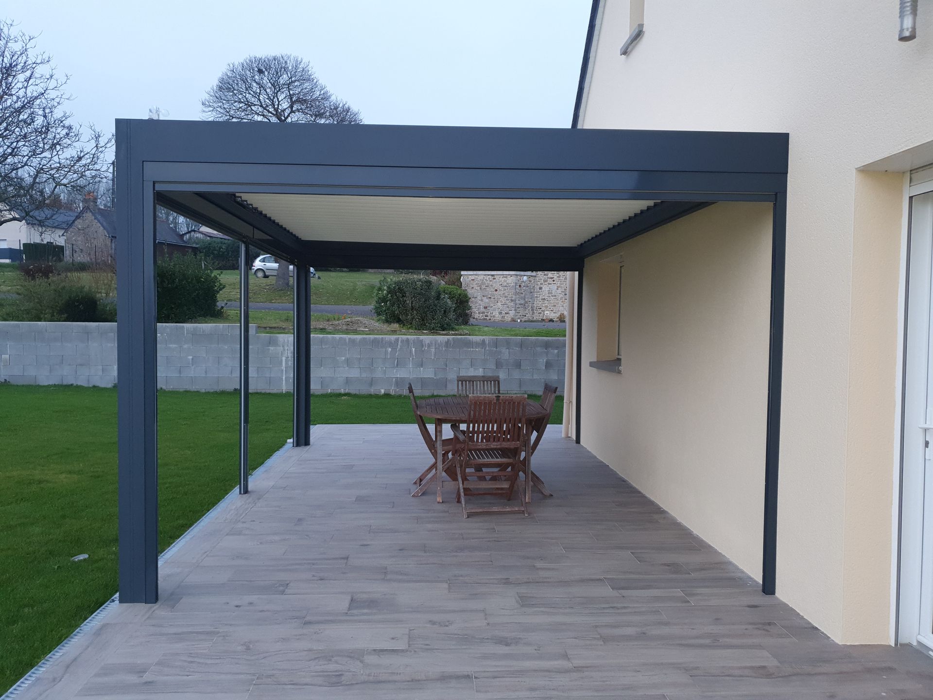 Pergola avec table et chaises en bois dessous