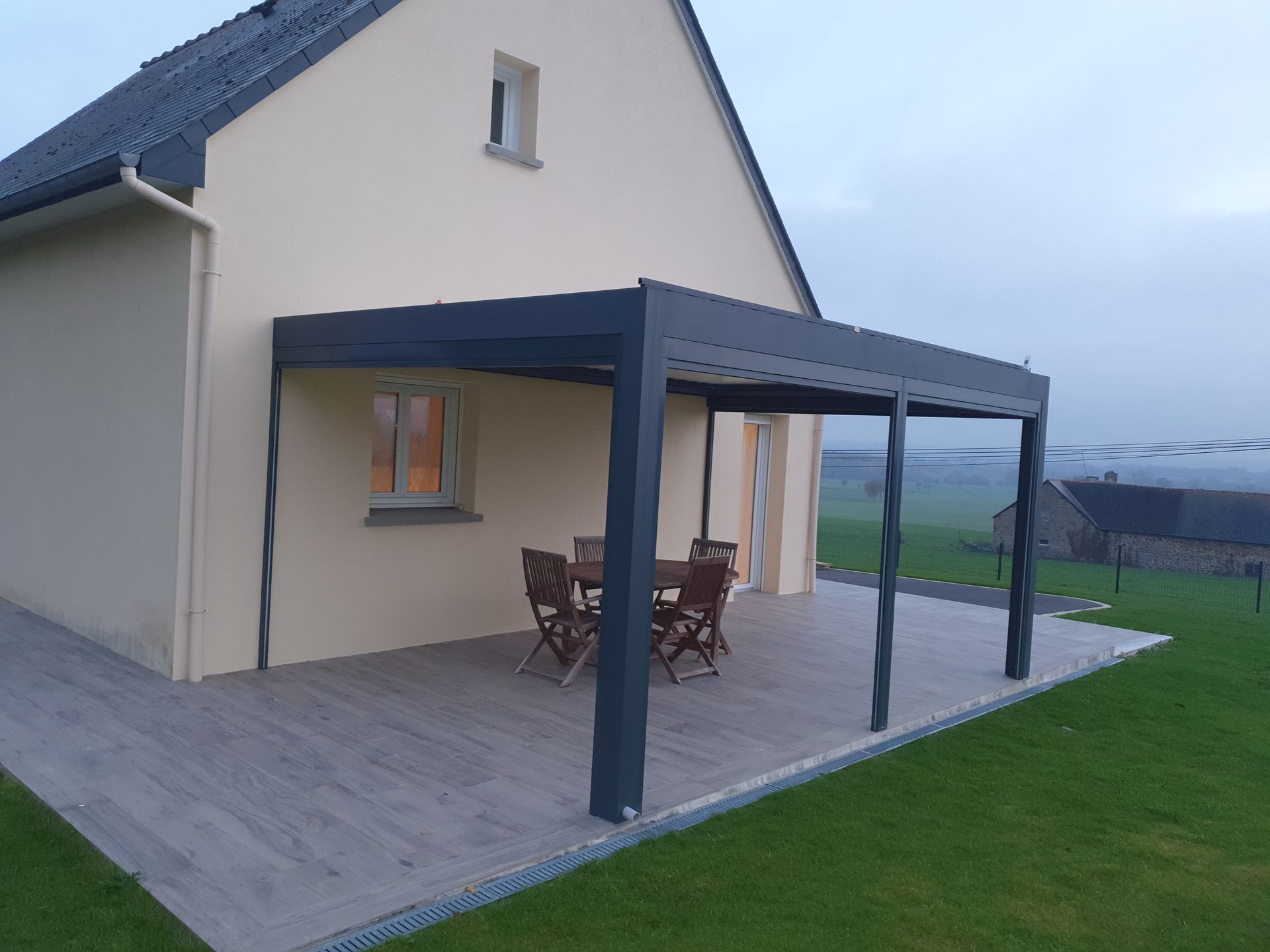 Pergola bioclimatique devant une maison neuve