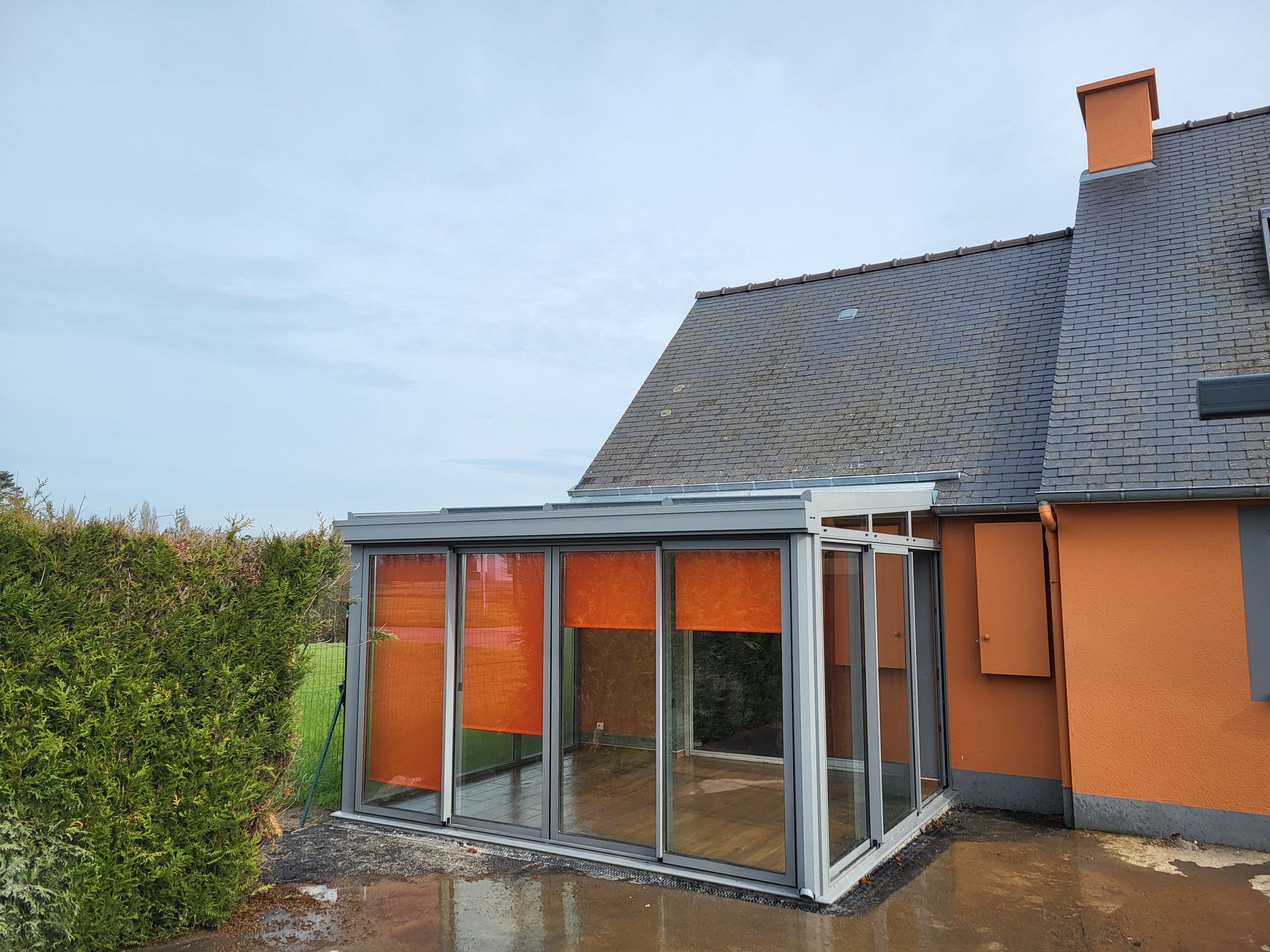 Véranda en aluminium avec des stores orange