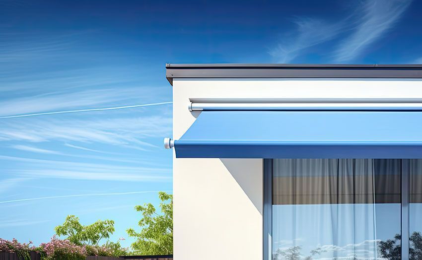 Façade d'une maison avec un store banne bleu