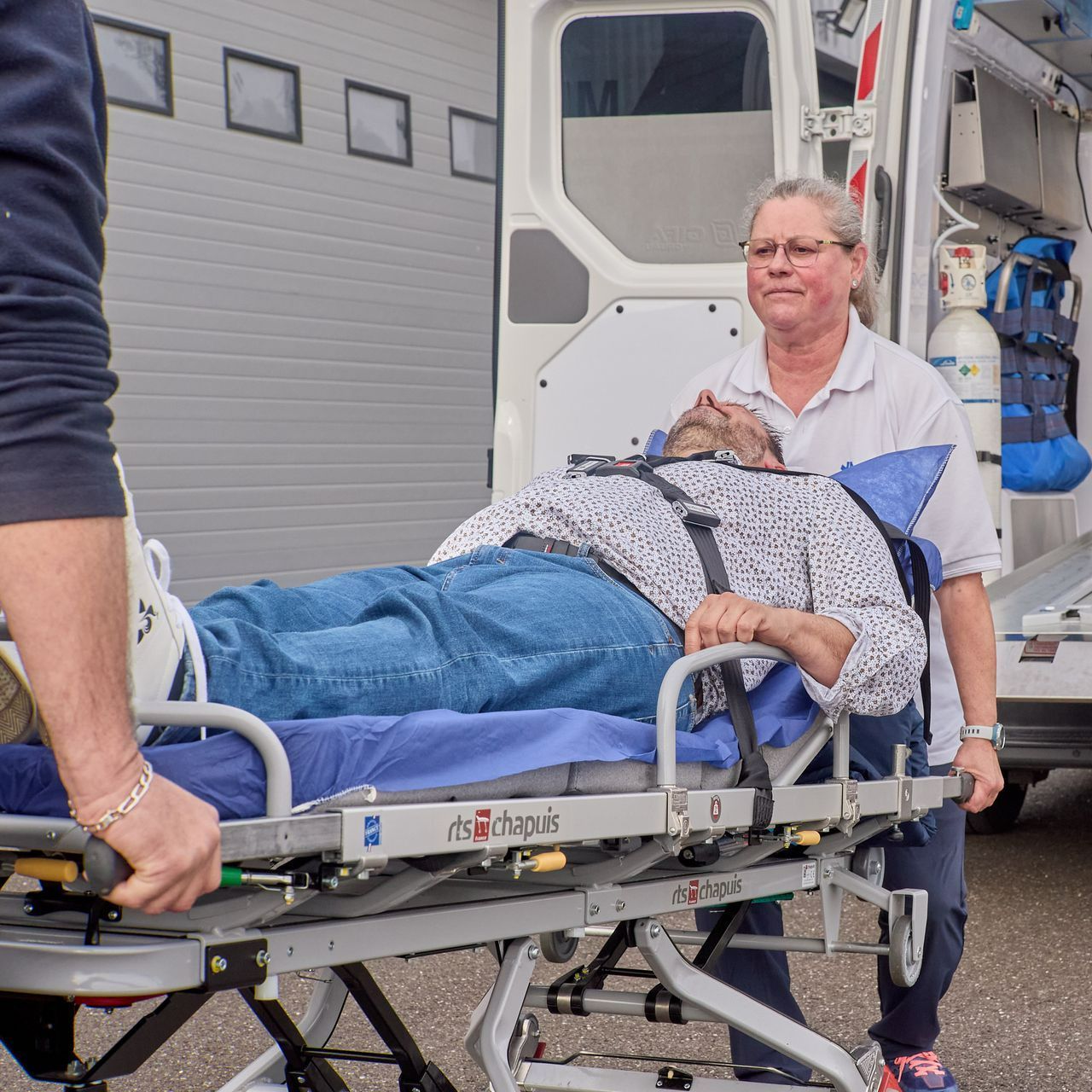Brancard avec patient manipulé par une ambulancière