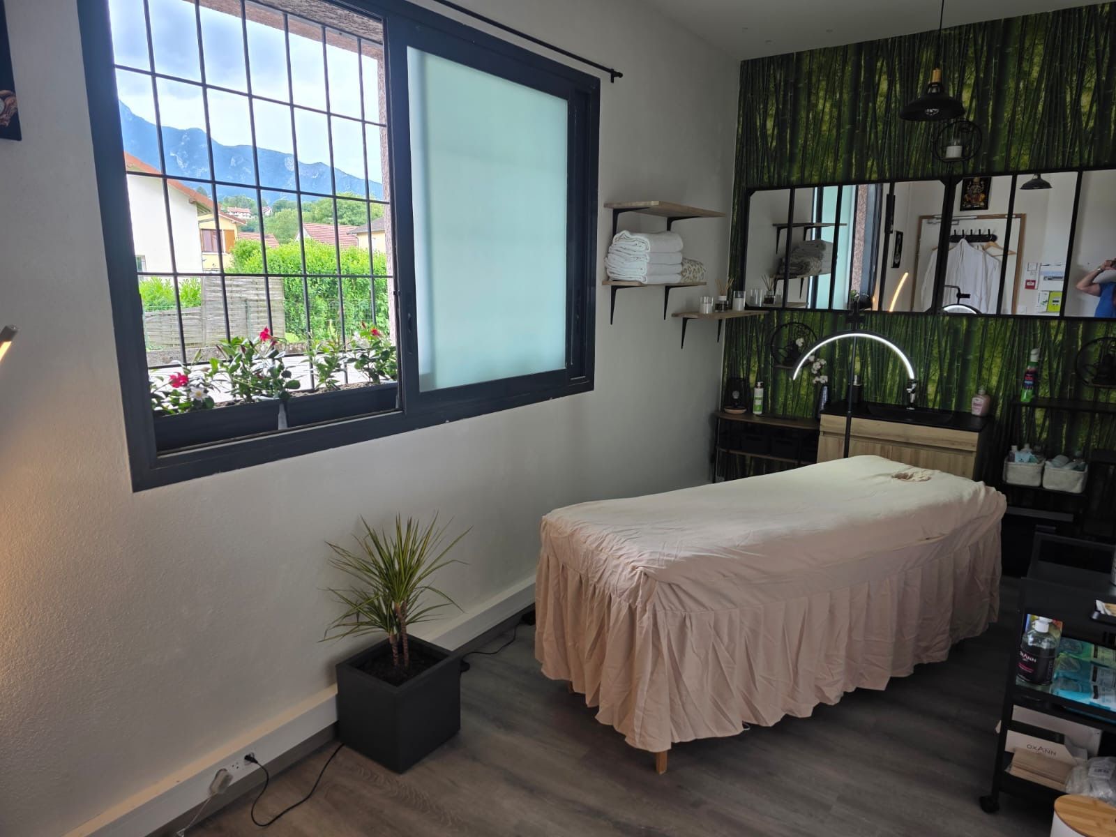 Une chambre douillette avec deux lits, un fauteuil en osier, des miroirs, une échelle.
