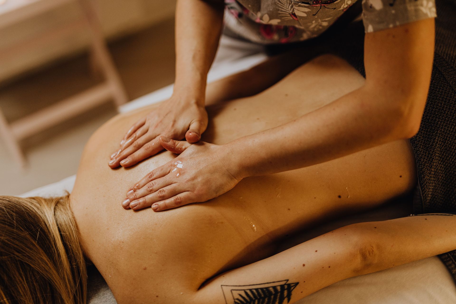Des mains massant le dos nu d’une personne lors d’un soin au spa