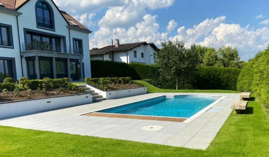 Il y a une grande piscine dans l'arrière-cour d'une maison.