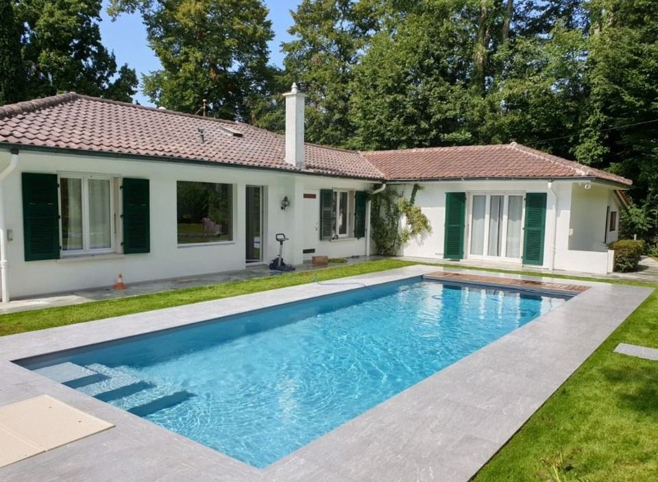 Une maison avec une grande piscine devant elle