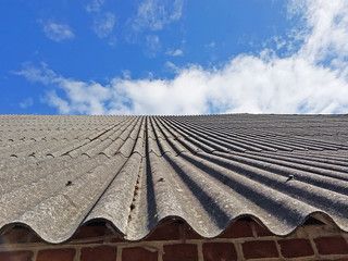 Mirando hacia arriba a un techo con un cielo azul en el fondo.