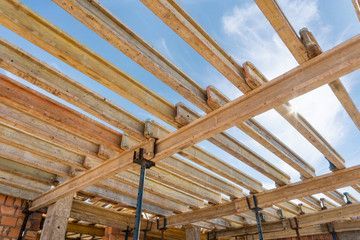 El techo de un edificio en construcción está hecho de vigas de madera.