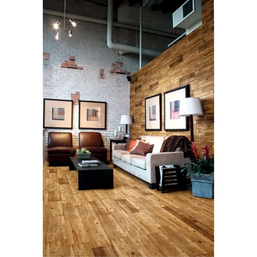 Una sala de estar con un sofá y sillas y un piso de madera.