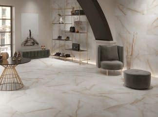 Una sala de estar con una mesa, una silla y una otomana.