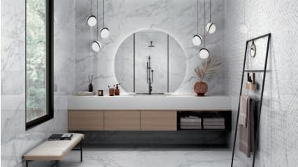 Un baño con lavabo, espejo, banco y ventana.