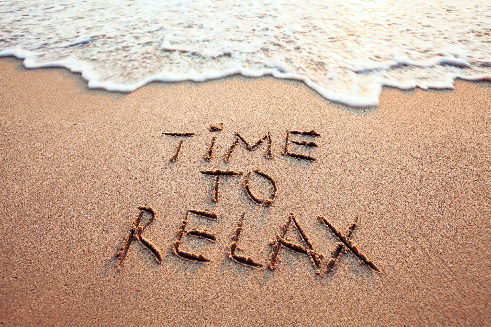 Plage de sable avec le message Time to relax symbolisant l'art-thérapie à Compiègne