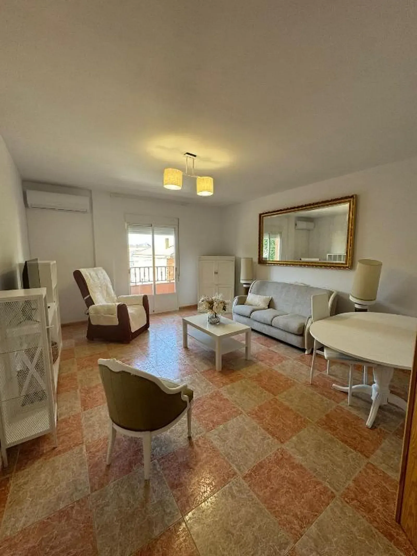 Dormitorio con dos camas, escritorio y armario blancos y balcón.