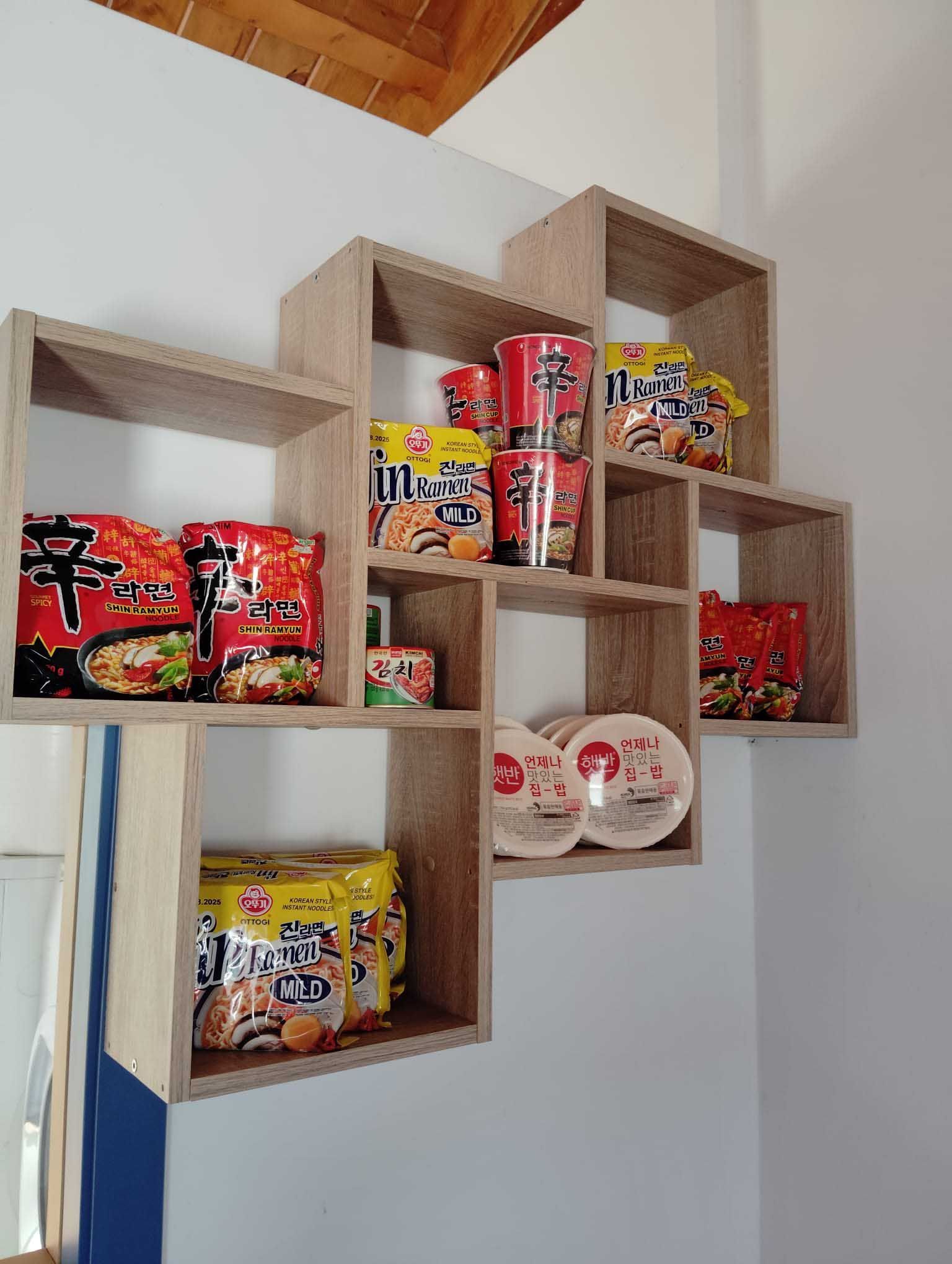 Un estante lleno de una variedad de fideos ramen y tazas.