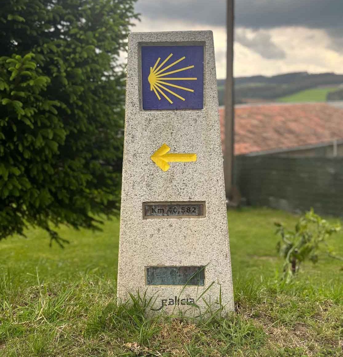 Un pilar de piedra con una flecha amarilla que apunta hacia la derecha