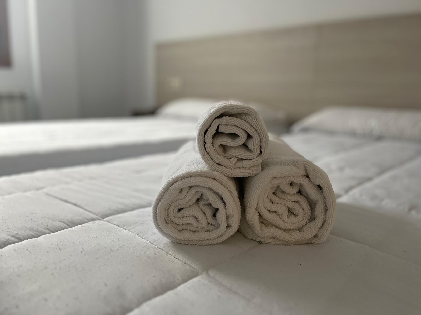 Tres toallas están apiladas una encima de otra sobre una cama.