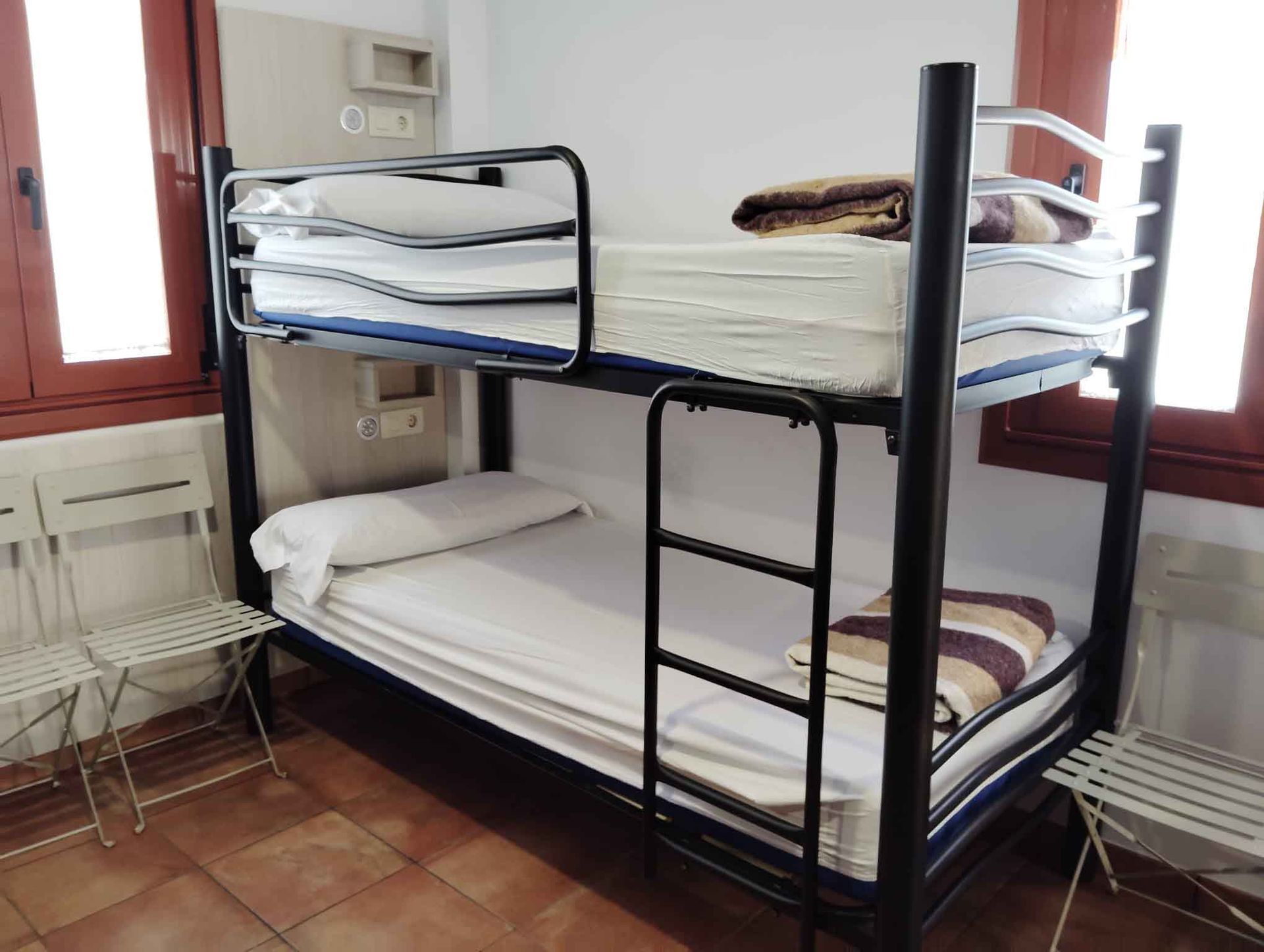 Un dormitorio con una cama, televisión y ventana.