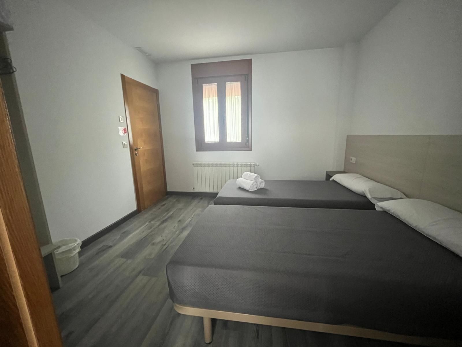 Un dormitorio con dos camas y una ventana.