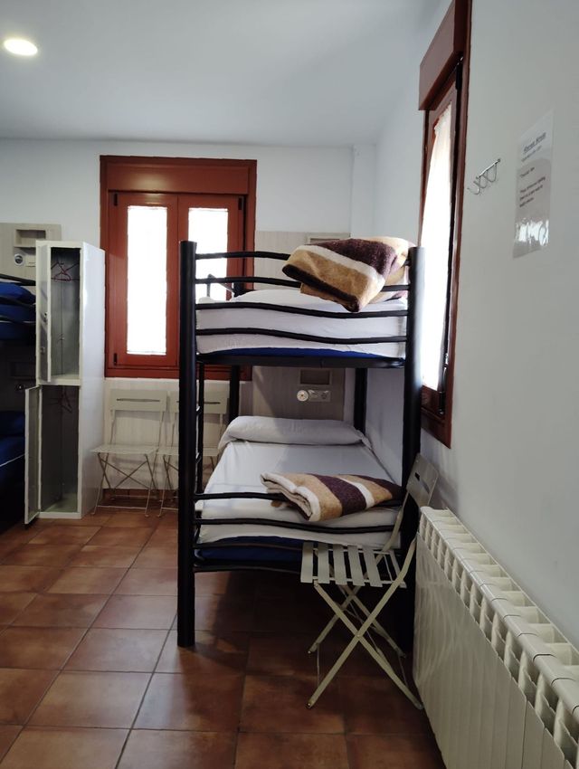 Una habitación de hotel con dos camas y suelo de madera.