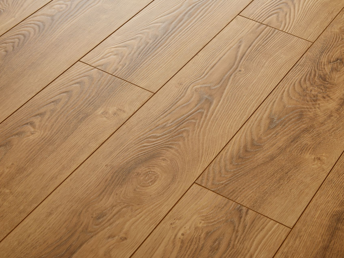 Gros plan sur des planches de parquet en bois brun clair, laissant apparaître le grain et les joints.
