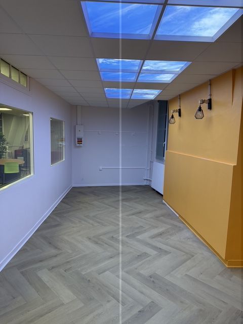 Couloir moderne vide avec plafonniers bleus, murs blancs et un mur d'accent jaune.
