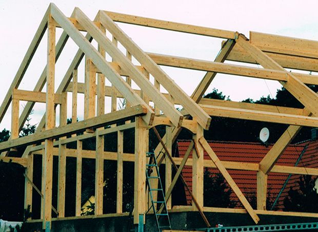 Im Freien sind die Bauarbeiten an der hölzernen Dachkonstruktion im Gange.